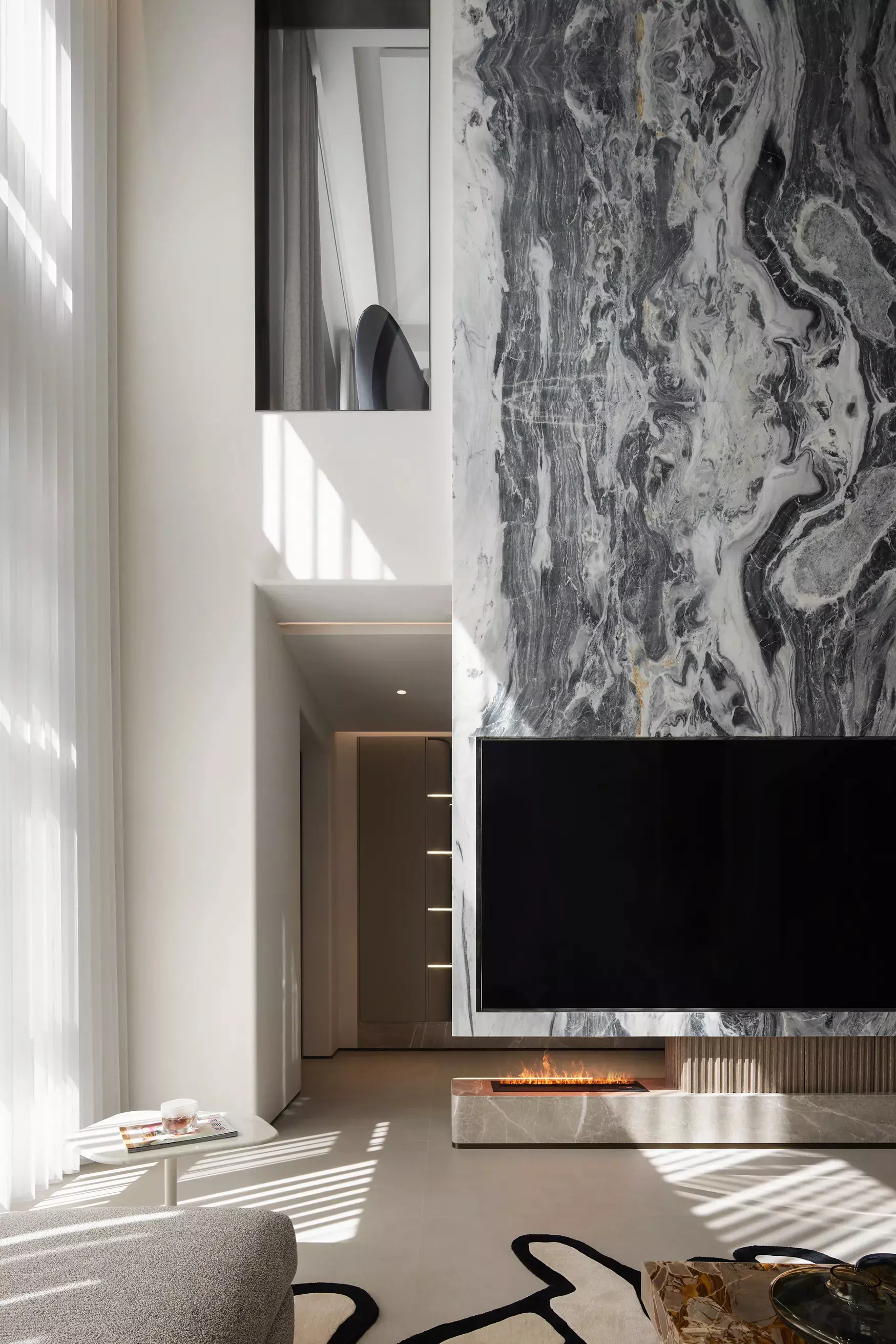 Grand double height living room design featuring a luxury crystal chandelier and floor to ceiling windows